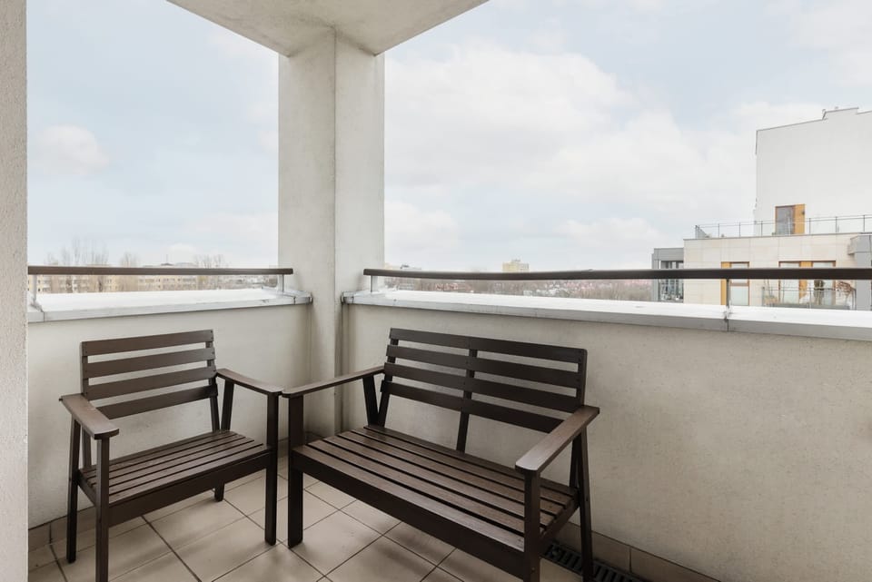 A balcony with outdoor seating and an expansive view.
