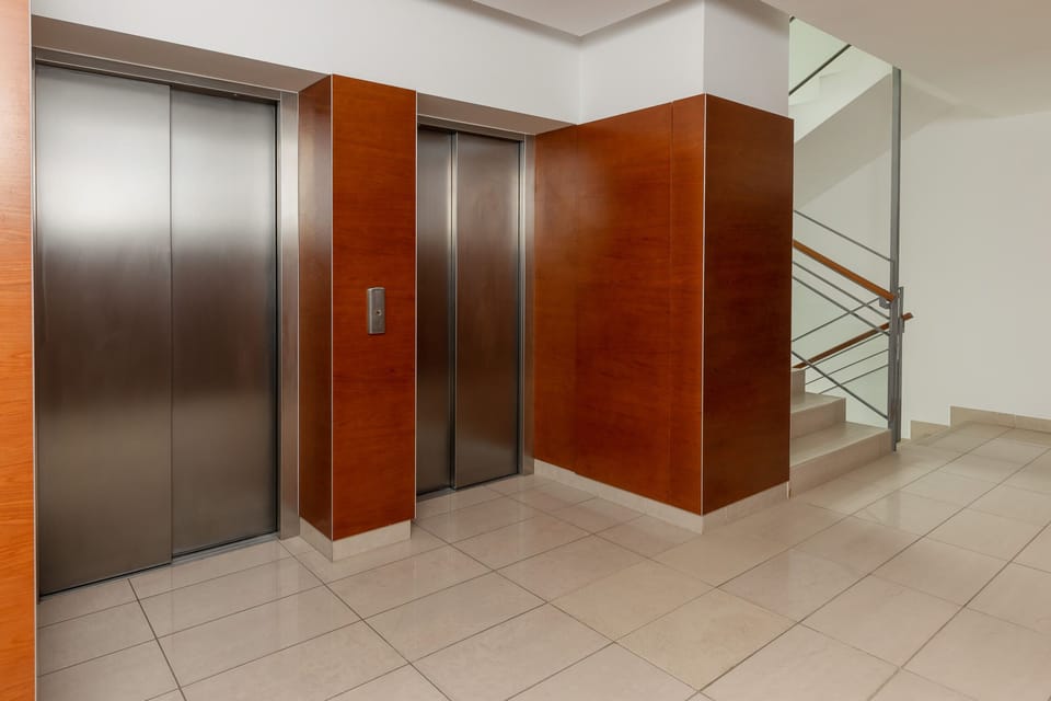 An interior view of an elevator lobby with sleek design and bright lighting.
