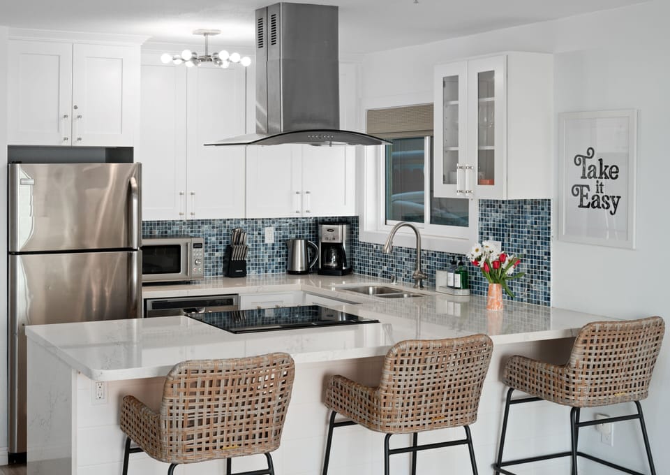 Kitchen with electric range, refrigerator, and drip coffee pot
