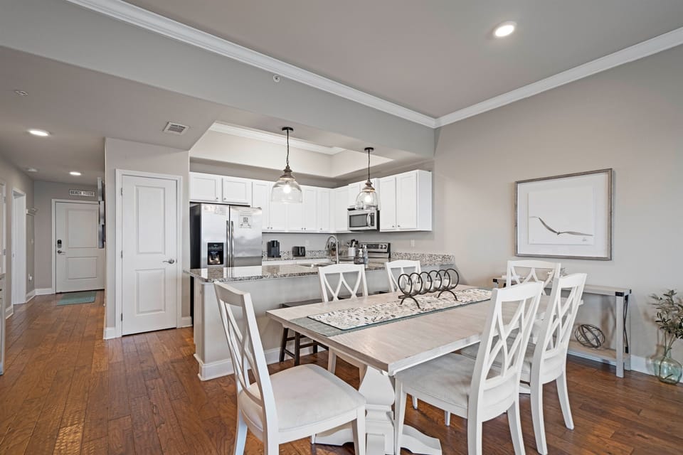 Gather around the farmhouse-style dining table with open sightlines to the kitchen—perfect for sharing meals and memories.