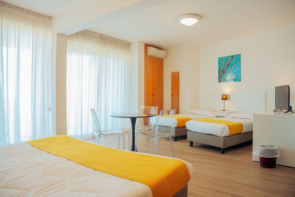 Standard Quadruple Room, Balcony, Pool View | Minibar, in-room safe, desk, soundproofing