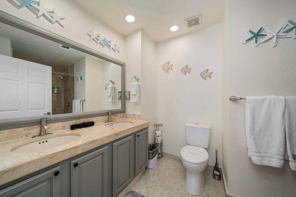 Double-sink vanity with modern fixtures and coastal decor for a relaxing refresh.