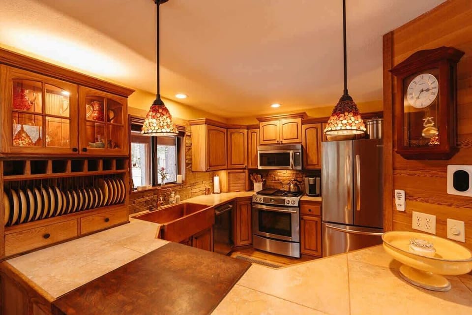 Quaint kitchen with stainless steel appliances and copper sink. 