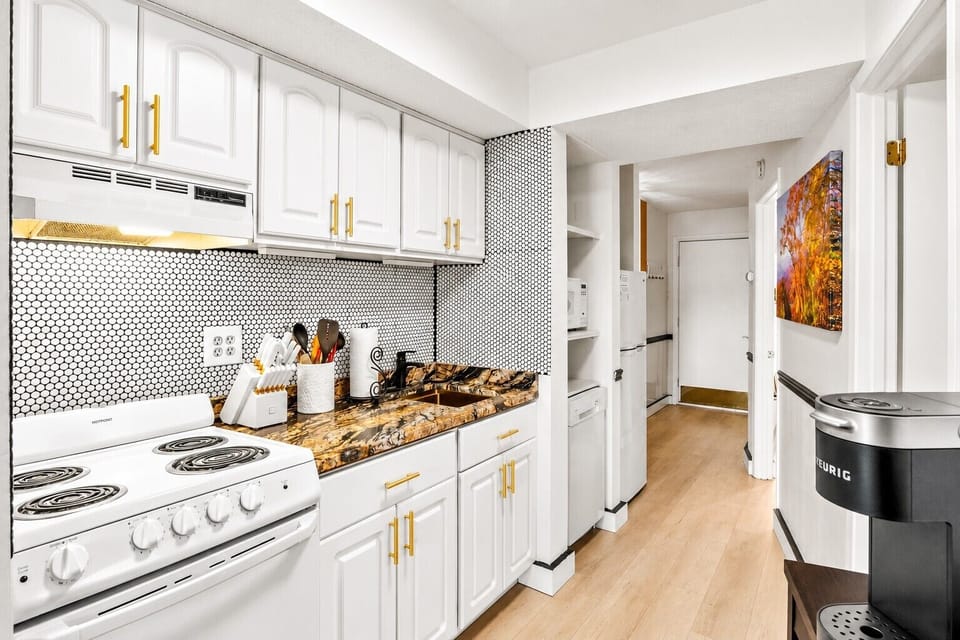 Fully equipped kitchen with gold hardware, penny tile backsplash, and gorgeous granite countertops