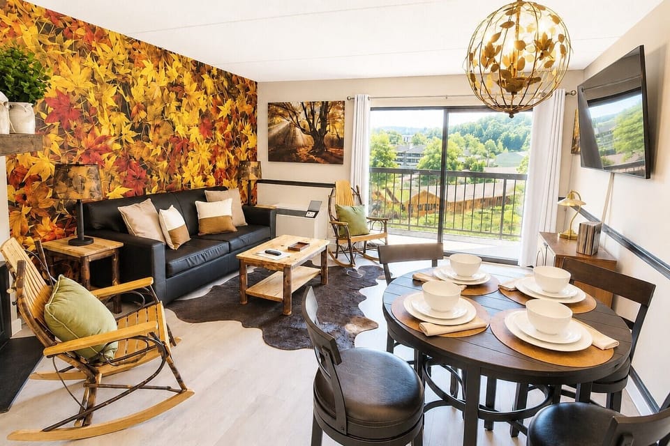 A cozy mountain retreat with warm autumn accents, plush seating, and a private balcony overlooking the Smokies. The perfect space to share a meal, relax, and soak in the view