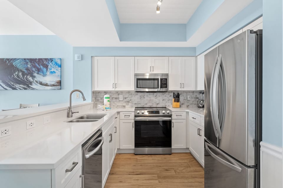 Kitchen has quartz countertops, stainless appliances - fully stocked with more than the basics (coffee/tea bar, oils/spices, Tupperware, plenty of pots/pans/cookware)