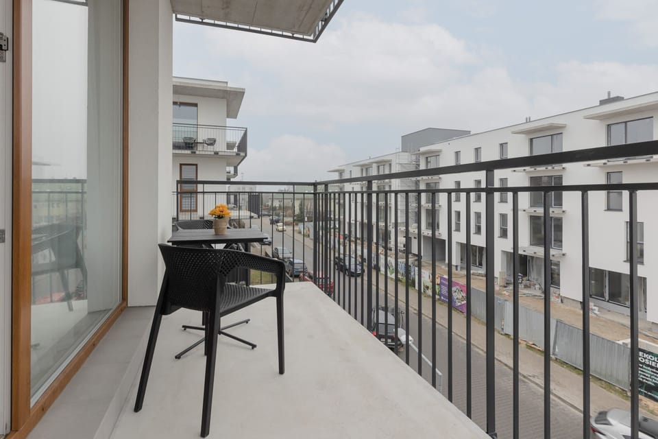 Spacious balcony with outdoor furniture. 
