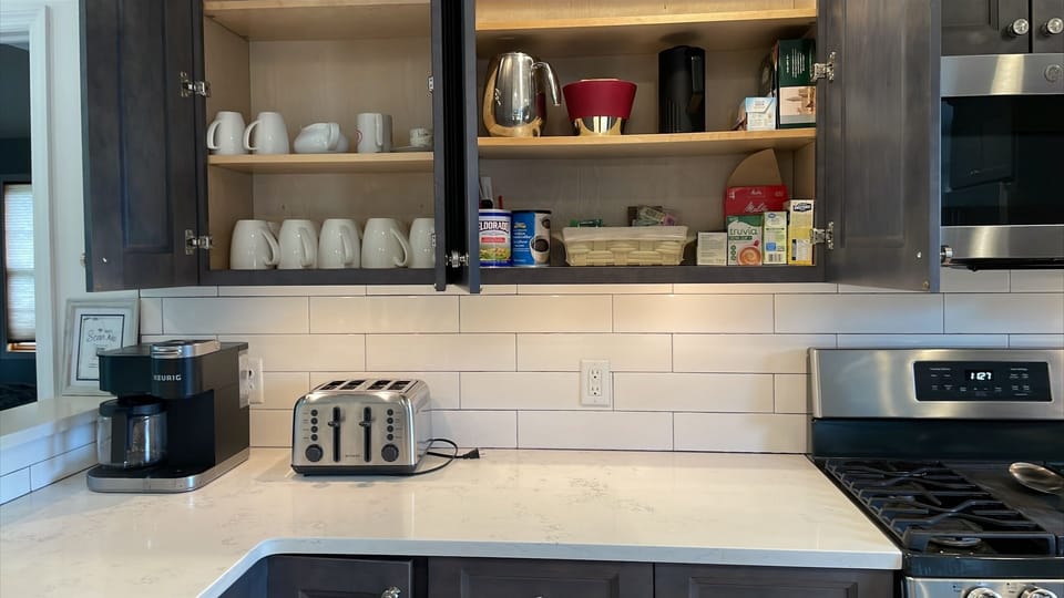 Well-equipped kitchen with coffee maker, toaster, cookware, and modern appliance