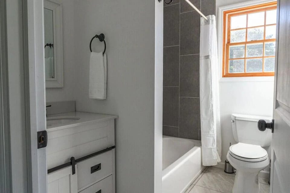 Bright bathroom with a walk-in shower, vanity, and natural light.