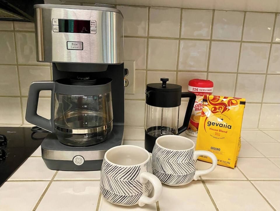 Coffee station in kitchen with 12 cup drip coffee maker and a French press. Additional liquid creamers in the fridge and sugar/sweeteners provided. Plenty of mugs. Tea bags for hot tea also provided. 