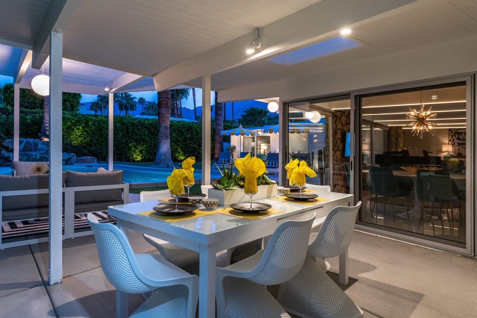 Outdoor dining for six at night on beautifully illuminated patio.  
