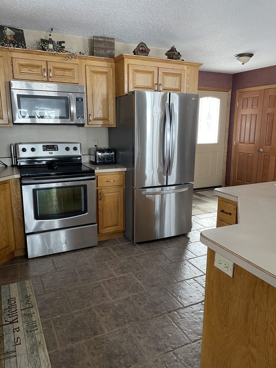 Stainless steel appliances in a fully-equipped conveniently arranged kitchen. 