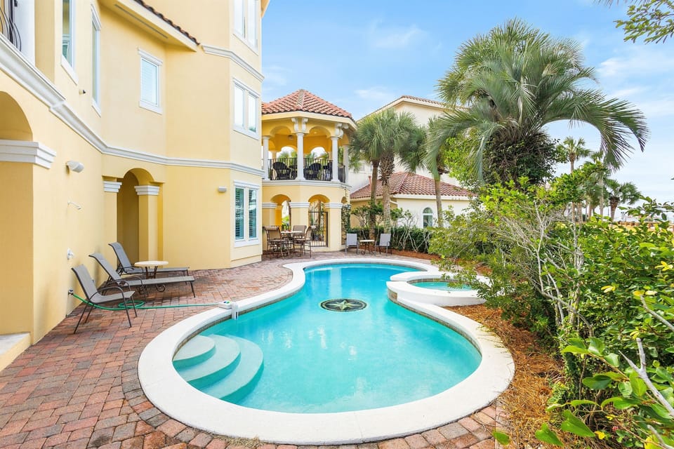 Your private oasis awaits with a sparkling pool surrounded by tropical palms and elegant Mediterranean architecture.