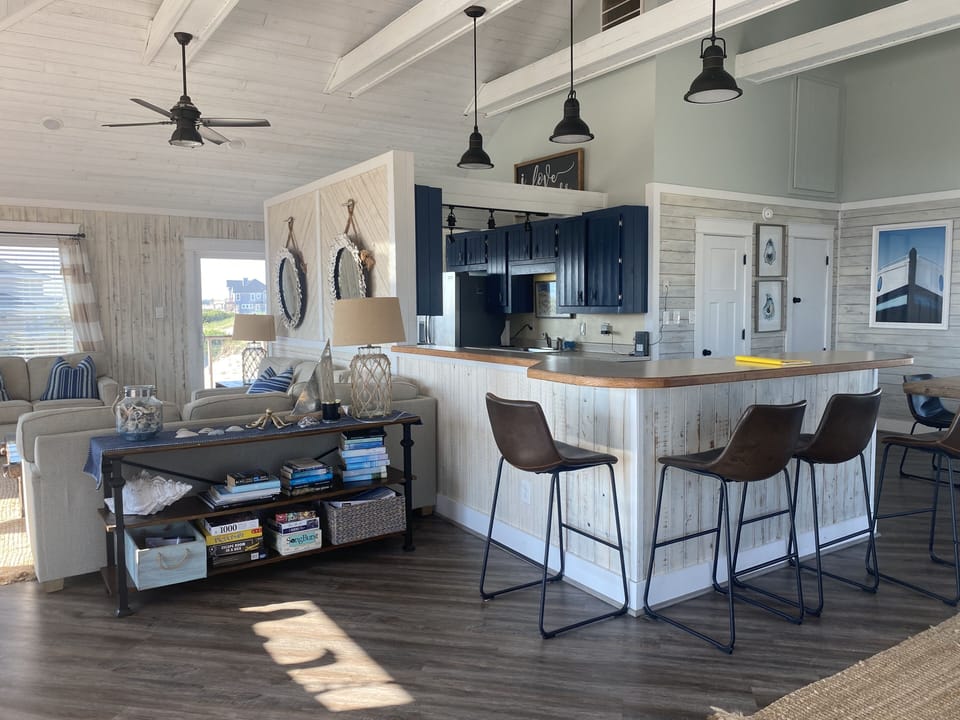 Top floor living space with open floor plan, four bar stool seating spaces. 
