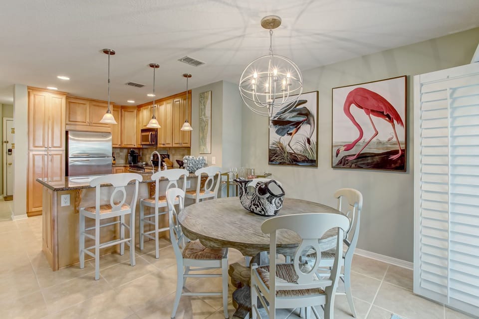 Dining Area with Table Seating for Four, Bar Stool Seating for Three and Overlooking the Private Balcony and Community Pool