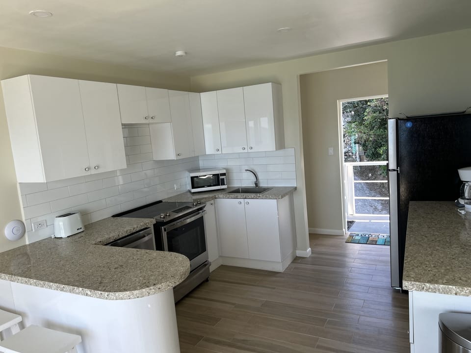 Kitchen with breakfast bar, dishwasher, stove, oven, fridge/freezer, microwave