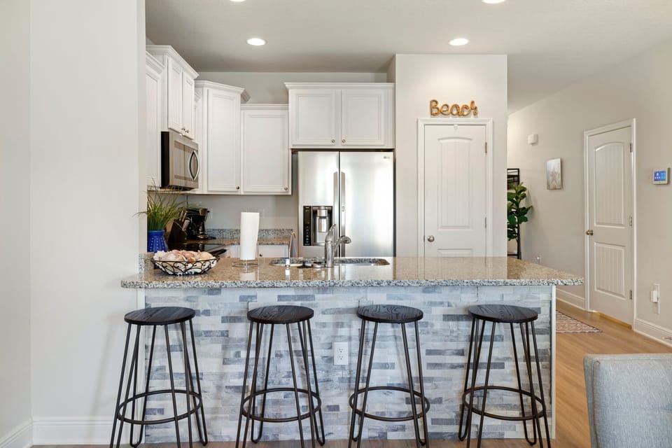 Open & fully stocked kitchen with 4 seats at the breakfast bar.