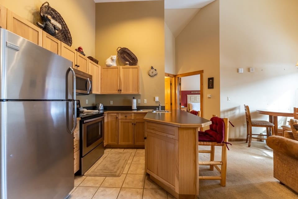 Your fully-equipped kitchen awaits with stainless steel appliances, warm wood cabinetry, and everything you need to create memorable meals together.