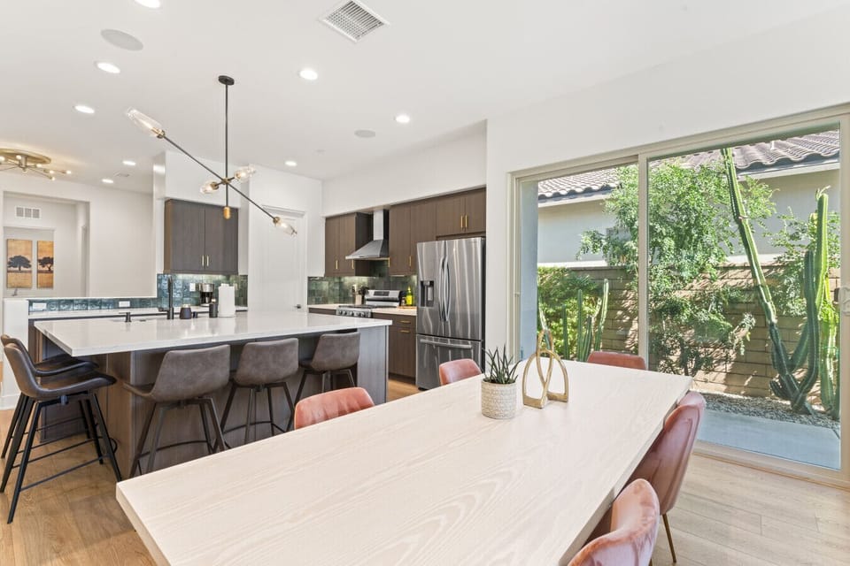 Light-filled dining area w/ spacious table & open views into the modern kitchen