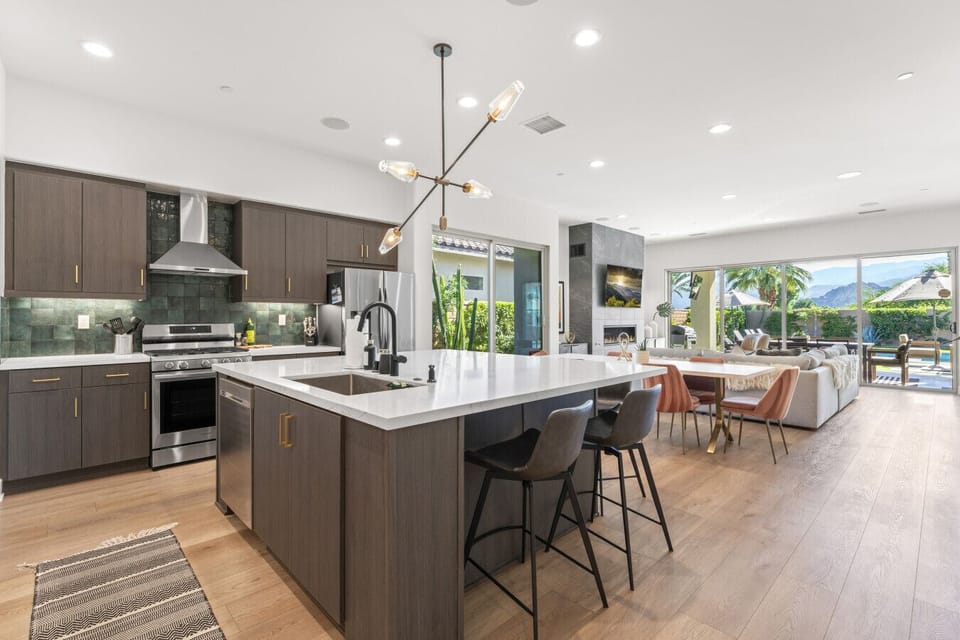 Sleek open kitchen w/ large island seating, modern finishes & seamless flow to dining area
