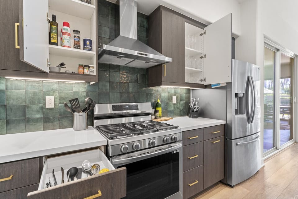 Modern kitchen w/ stainless appliances, tiled backsplash & plenty of prep space