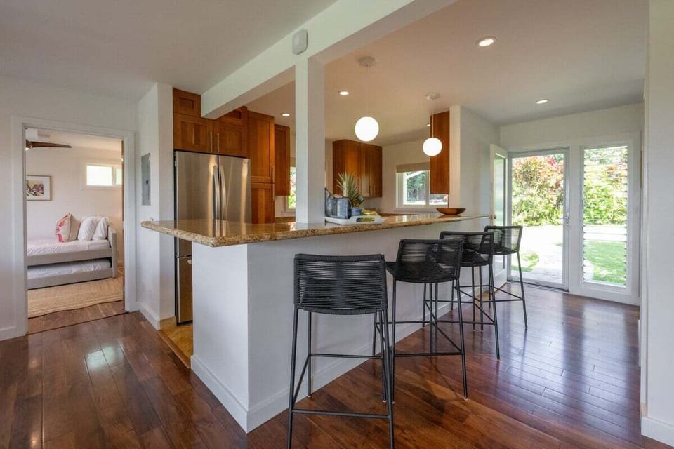 Gather around a stylish kitchen bar with granite countertops and modern high stools, perfect for casual dining and conversation.