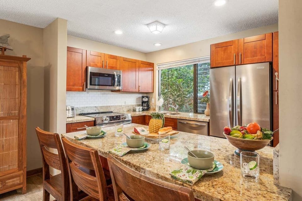 A fully equipped kitchen with sleek countertops, warm wood cabinetry, and a convenient breakfast bar for casual dining.