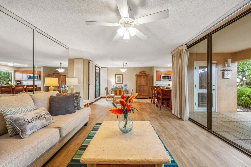 A bright and inviting living room with modern furnishings, warm lighting, and seamless indoor‑outdoor flow through large sliding glass doors.