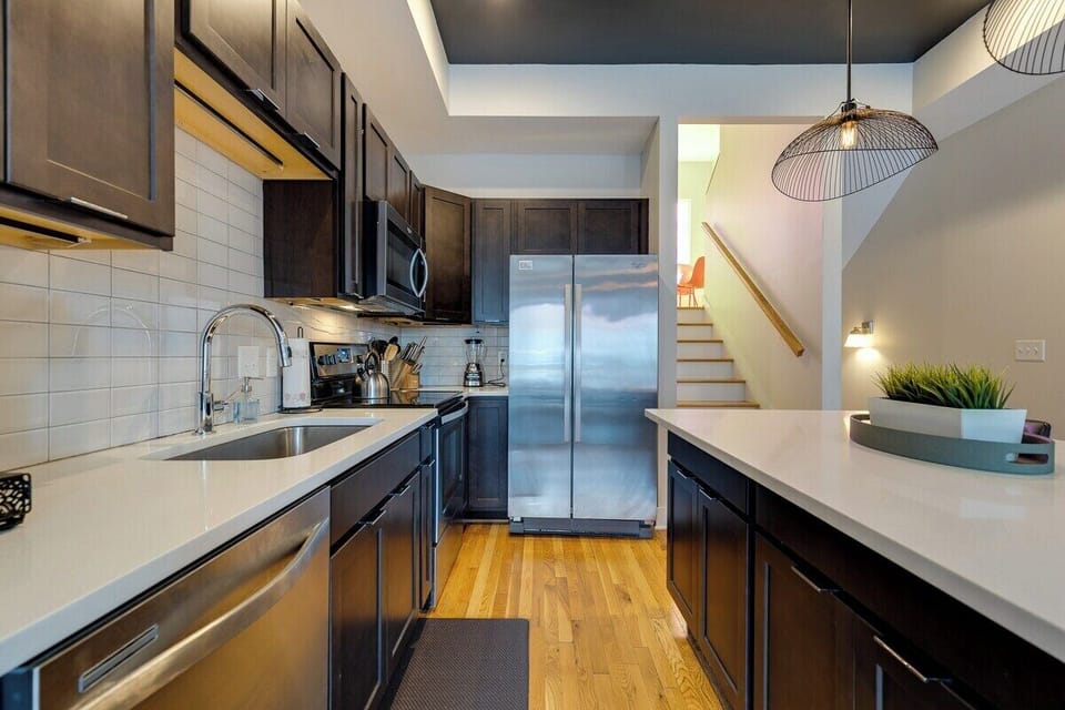 Stainless appliances in kitchen along with deep basin sink