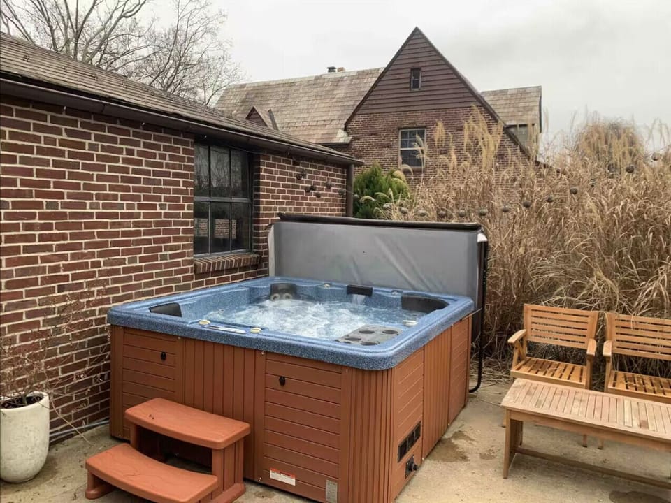 Outdoor hot tub and wooden bench on a patio