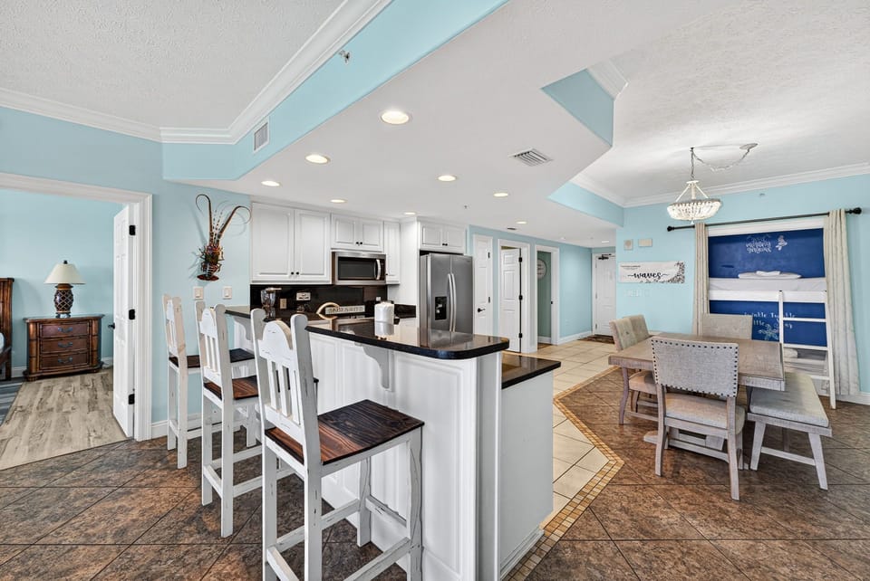 Open kitchen and dining area with modern appliances and coastal decor.