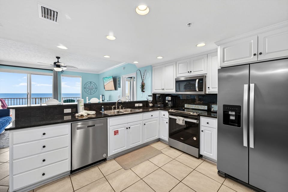 Modern kitchen with stainless steel appliances and ocean views.
