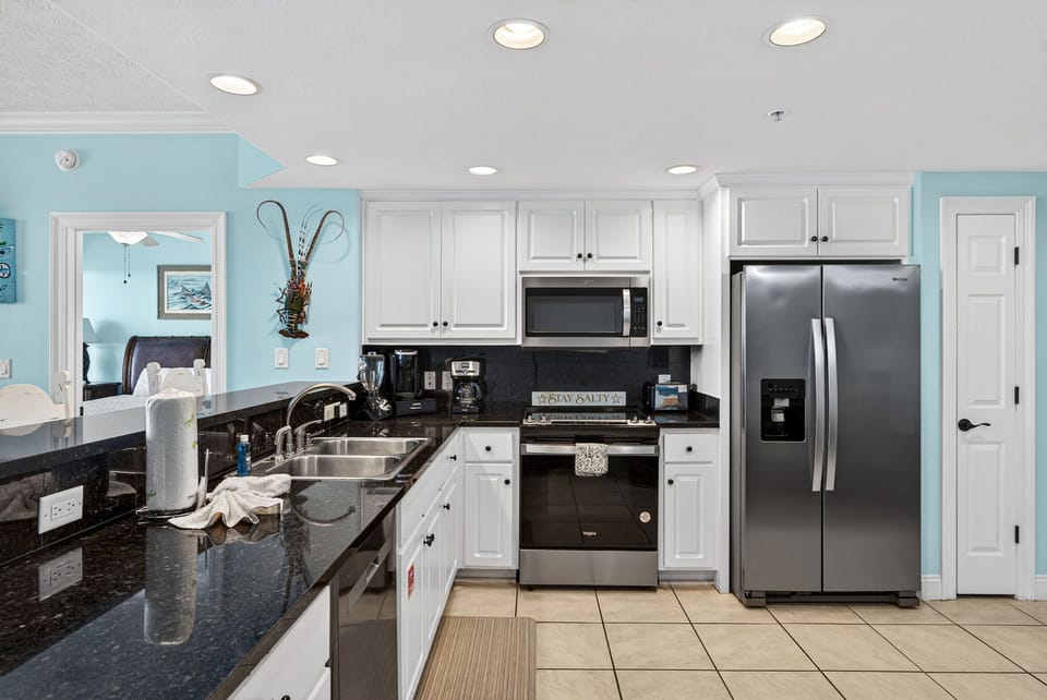 modern kitchen with stainless steel appliances and black granite countertops