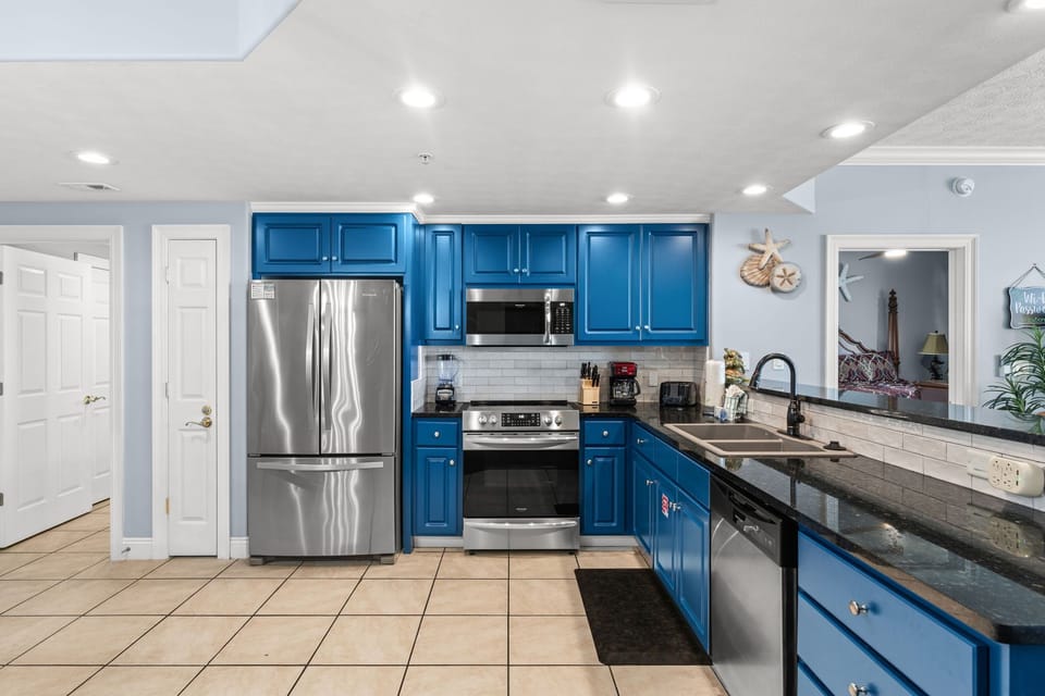 Whip up your favorite meals in this fully-equipped kitchen with bold blue cabinetry, stainless appliances, and ample counter space for cooking and gathering together.