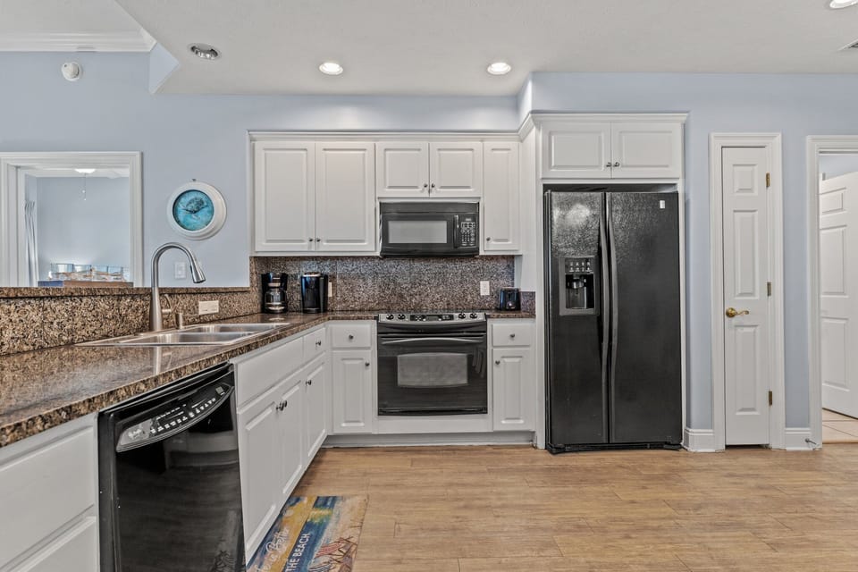 modern kitchen with black appliances and granite countertops