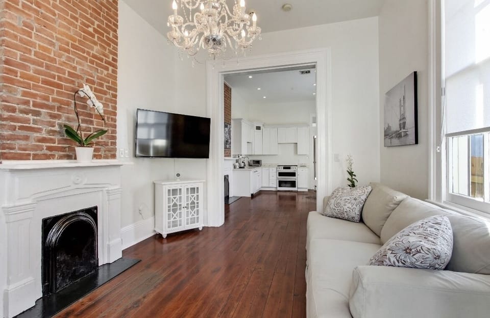 Cozy living room with sofas, vintage brick and a flat screen TV. Bright light.