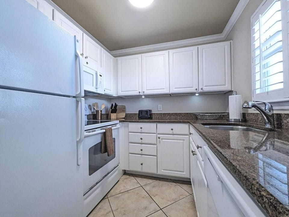 Clean, white kitchen w/ full-size appliances & plenty of counter space for home cooking