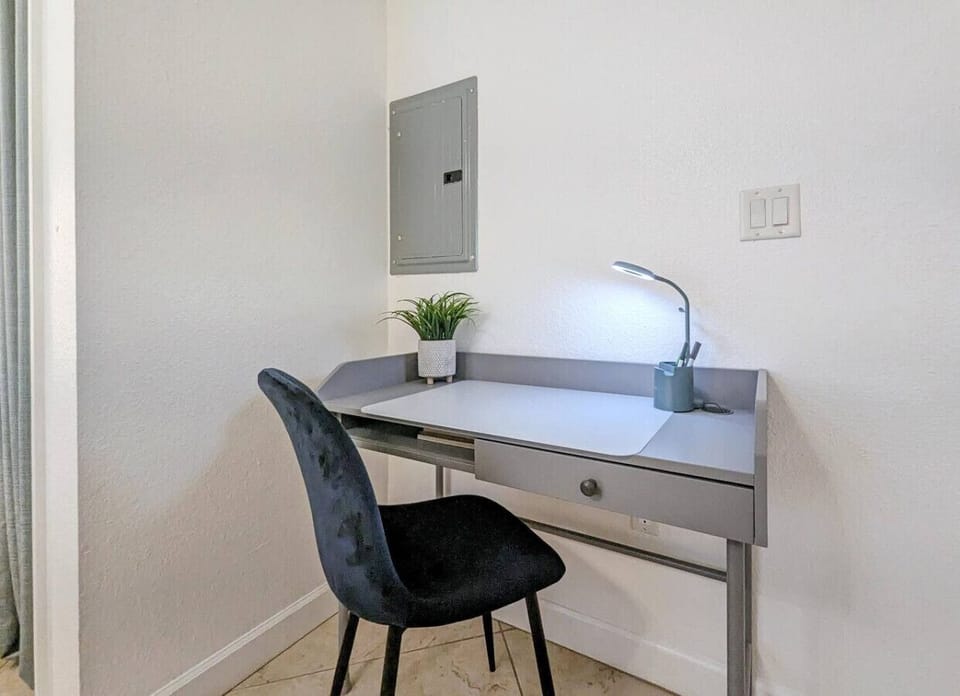 Compact desk nook w/ mirror & lighting, ideal for quick work or getting ready