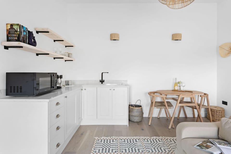 Kitchenette with sink and microwave, dining seating for 2 - The Sail Loft Suite