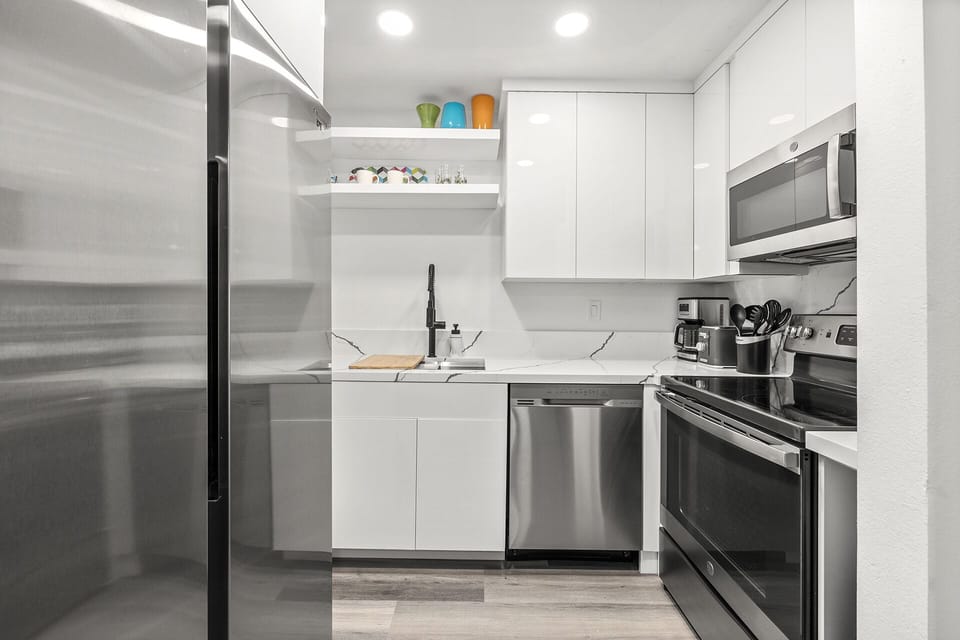 - Fully equipped Palm Springs kitchen with stainless steel appliances and quartz countertops   - Open shelving and sleek cabinetry add modern charm and convenience   - Ideal space to cook favorite meals during your Palm Springs getaway