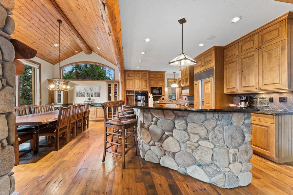 Your dream mountain kitchen awaits with warm wood cabinets, stunning stone island, and rustic beams overhead.