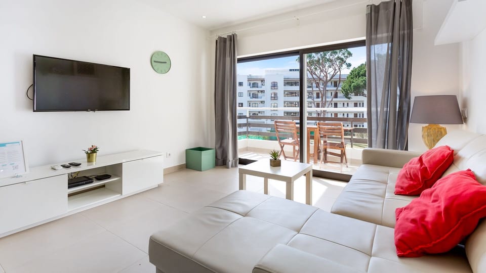Living area with a comfortable couch and a flat screen TV #bright #modern