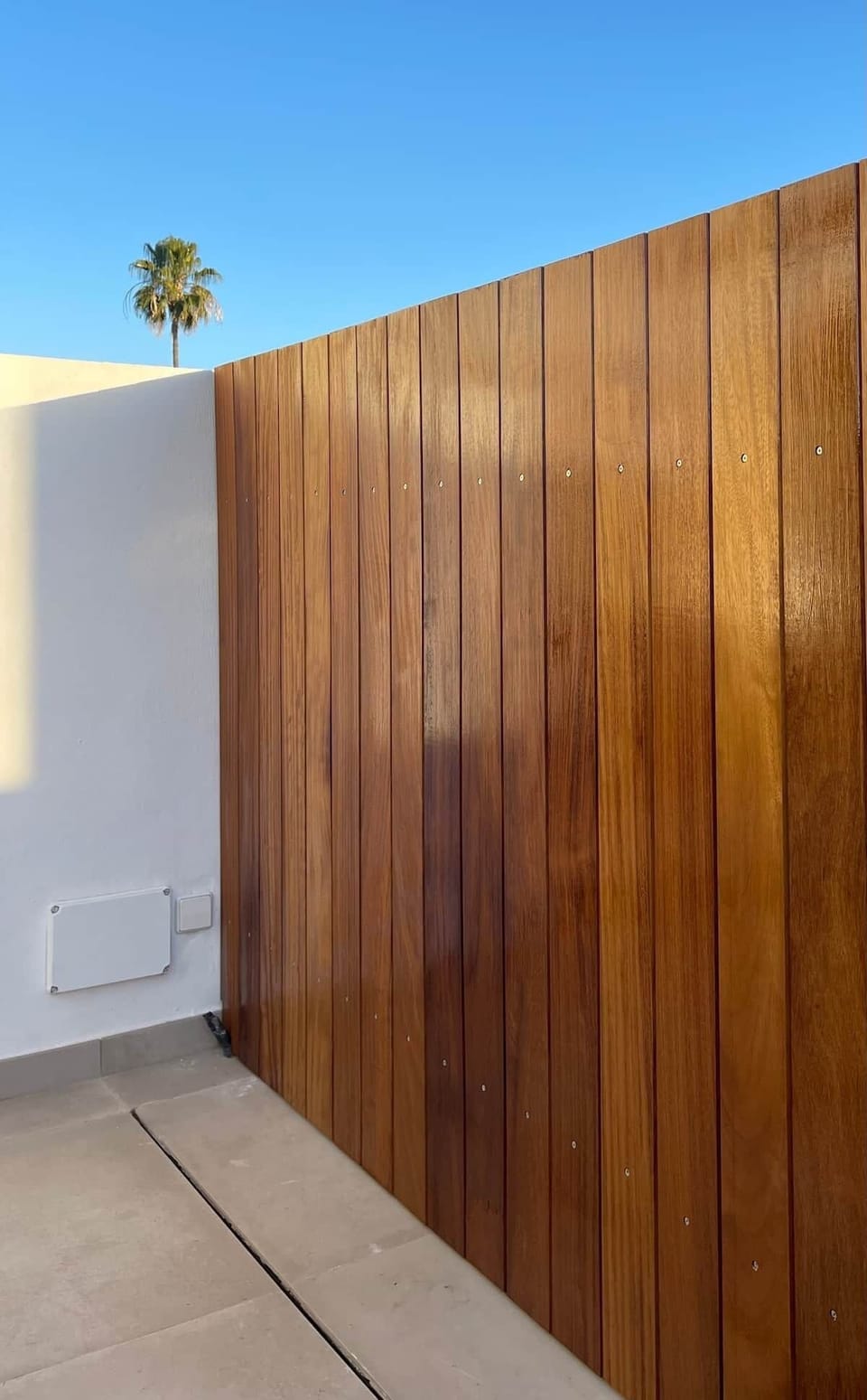 Gran terraza de 40m2 orientación sur con gran toldo automático con mando a distancia y conjunto de sofás y mesa para 5 personas con preciosa valla de iroko natural.