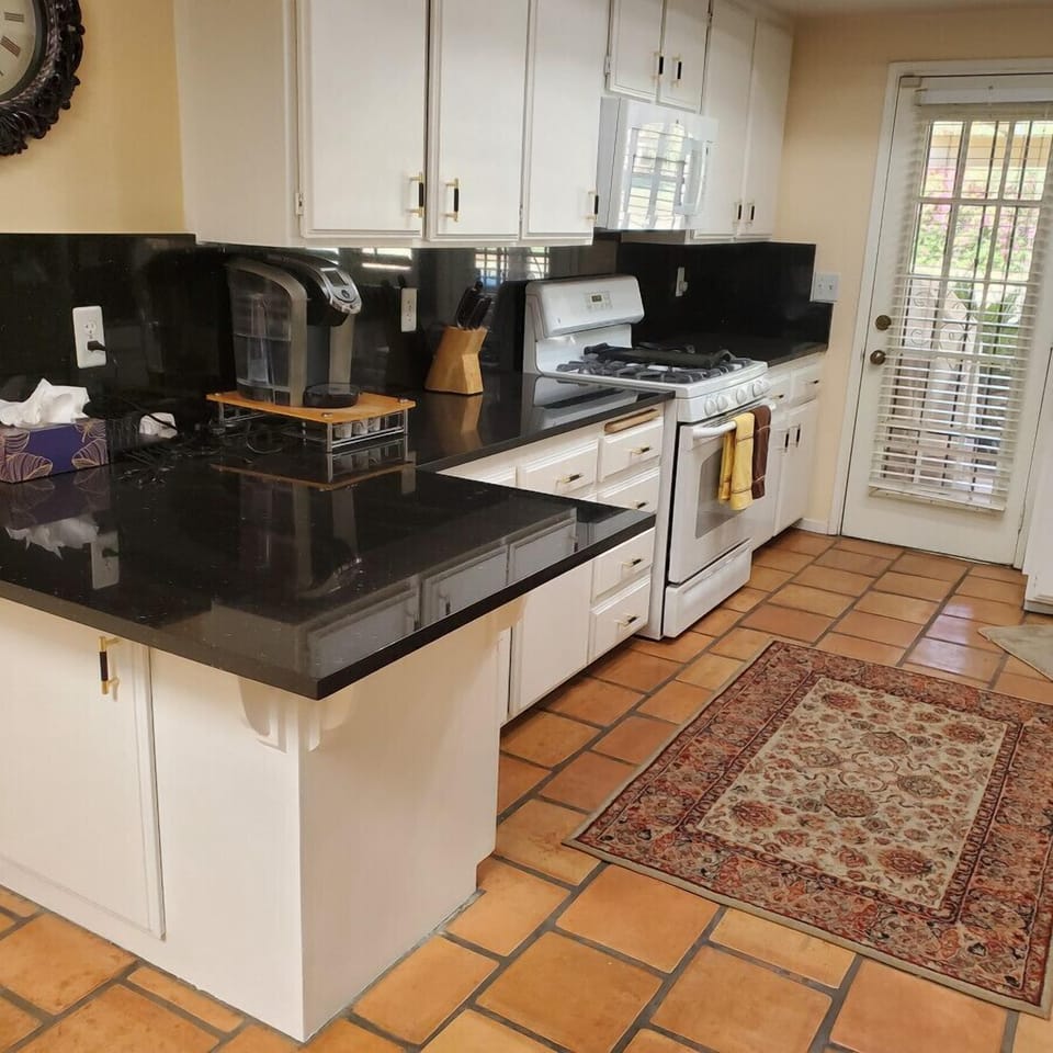 Remodeled kitchen with stunning black countertops with white cabinetry