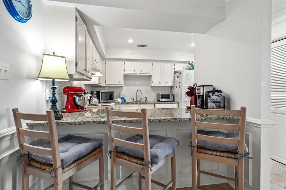 Your fully equipped kitchen features granite counters, quality appliances, and a breakfast bar where you can enjoy morning coffee.