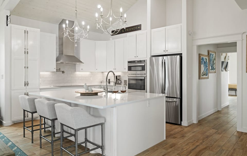 Kitchen — White Cabinets, Quartz Island, Gray Industrial Stools, 'Food & Friends' Sign & Chandeliers