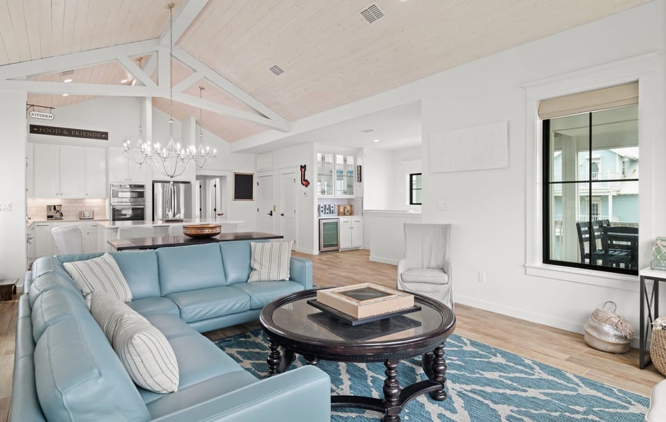 Living Room — Blue Leather Sectional, 'Kitchen/Food & Friends' Signs, Bar Area with Wine Cooler & Balcony View