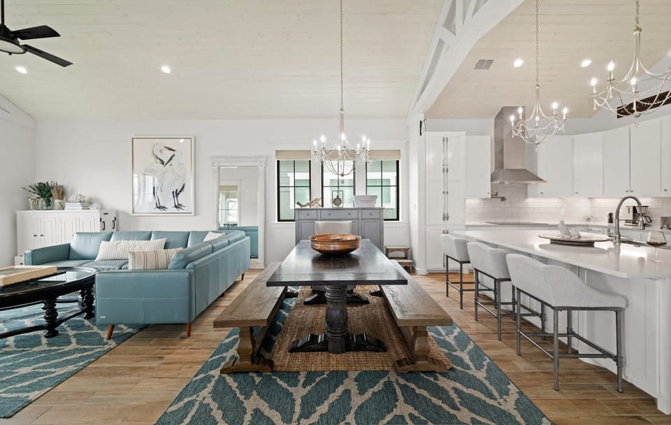Open Floor Plan — Farmhouse Dining Table with Bench, Copper Bowl, Blue Sectional, Chandeliers & White Kitchen Island