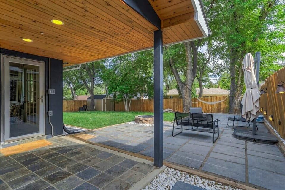 Unwind on the covered patio with comfy seating and a shady umbrella—an easy spot for morning coffee or a quiet evening outside.