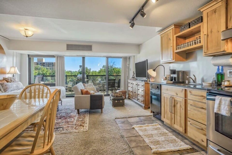An open kitchen and dining area with a wooden table, matching chairs, and ample counter space, all connected to the living room. The layout makes it easy to cook, gather, and linger over meals in one shared space.
